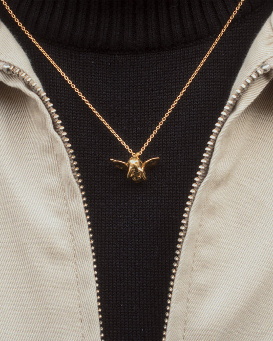 Cupid Necklace in gold worn with black turtleneck