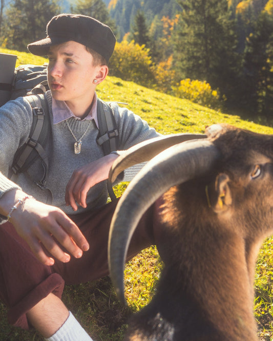Guy in camper look with goat in front of him