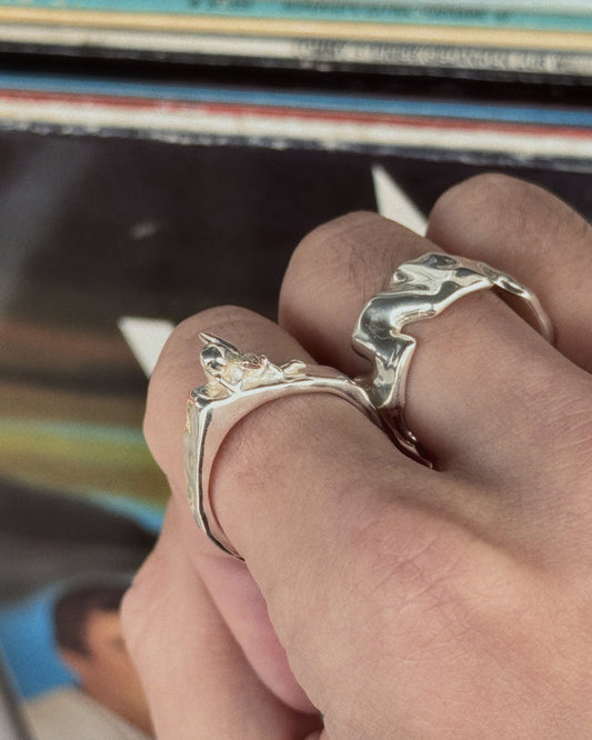 Human Ring in silver next to Cupid Ring worn