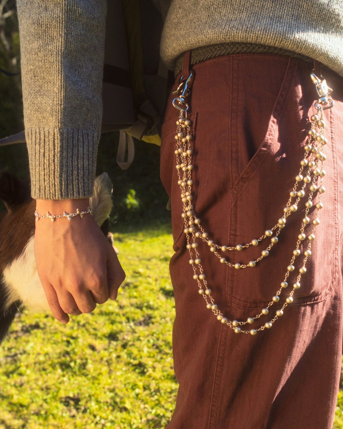 2x2 Wallet Chain worn on red pants while feeding a goat