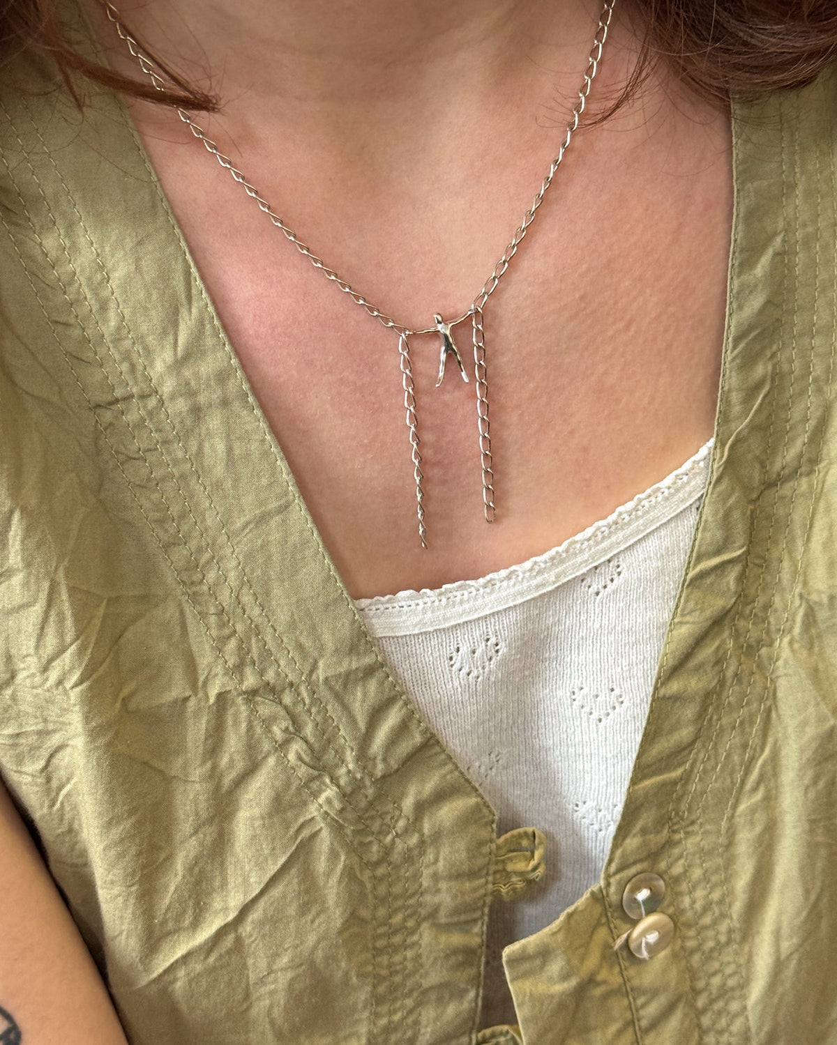 Hang By A Thread Necklace worn by female with a white tanktop and green jacket