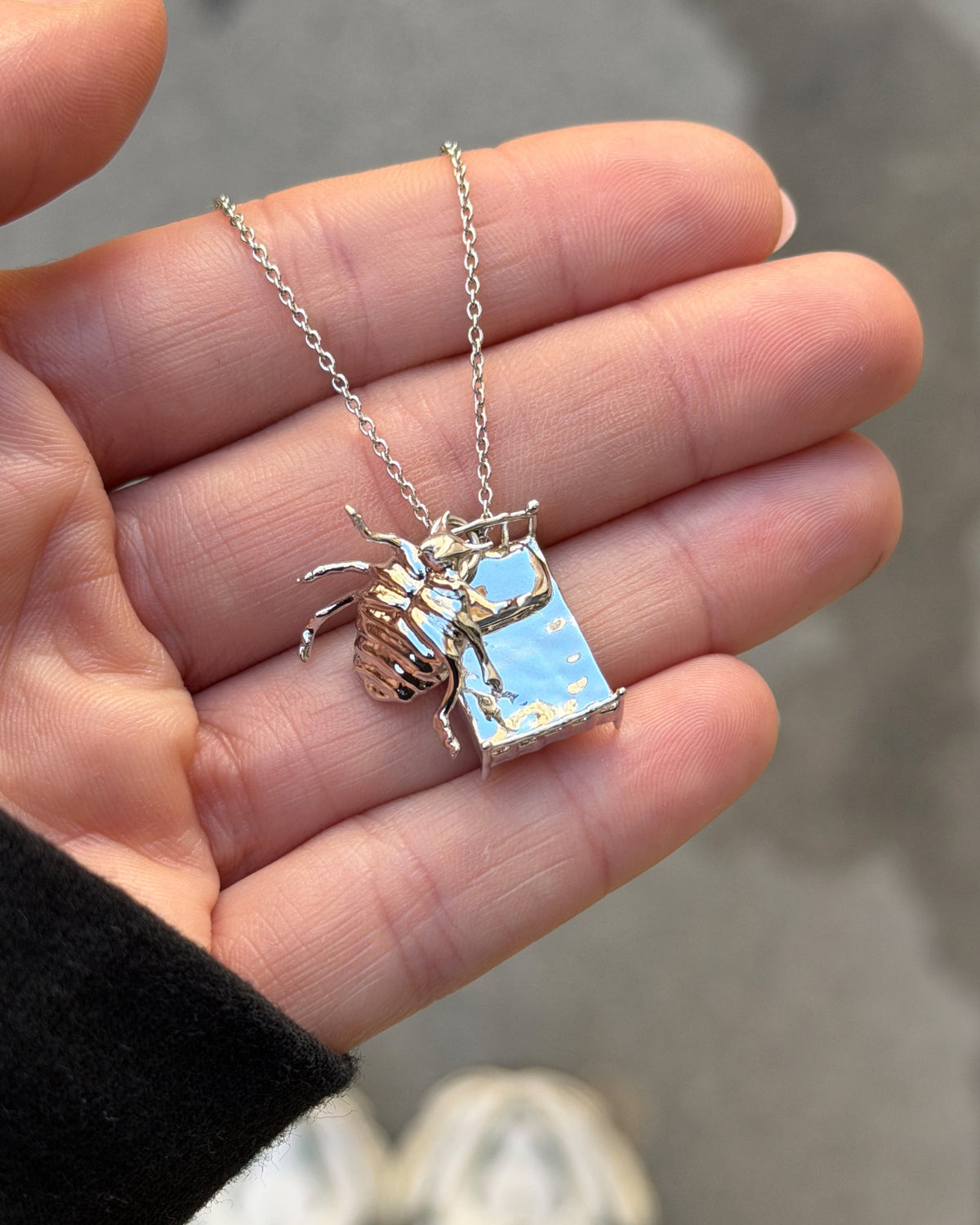 Gregor Samsa Necklace in silver held in hand