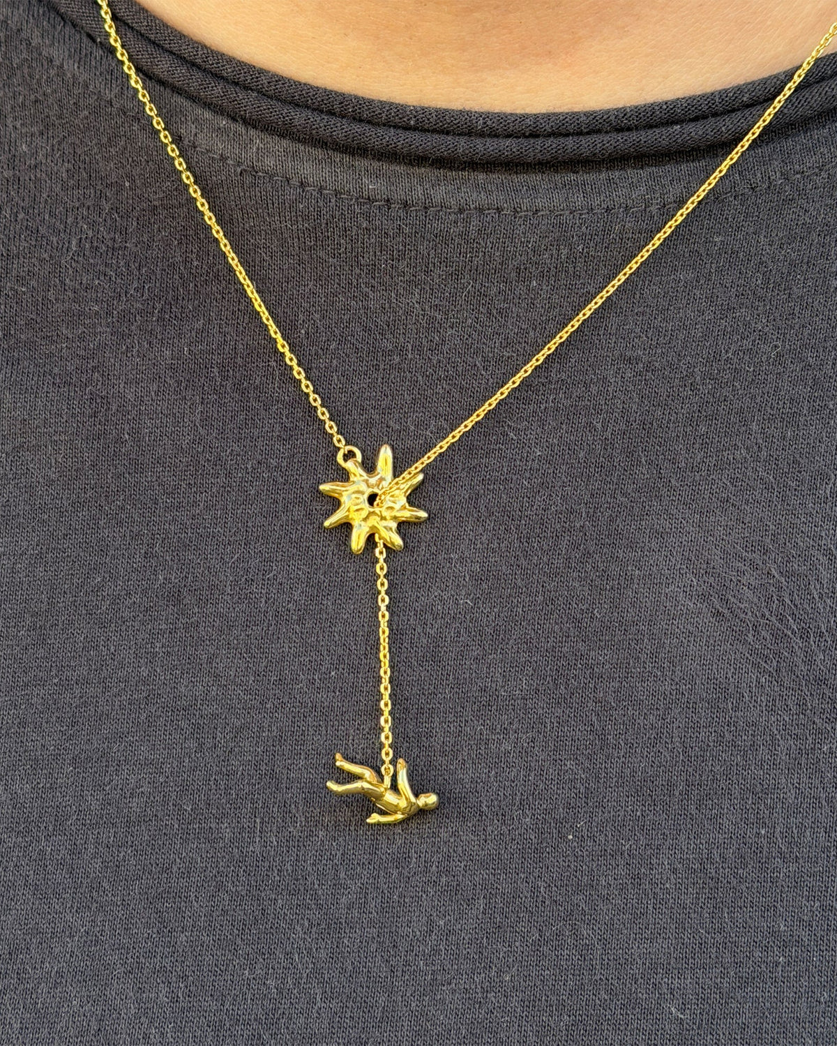 Icarus Necklace being worn in gold with a dark grey tshirt