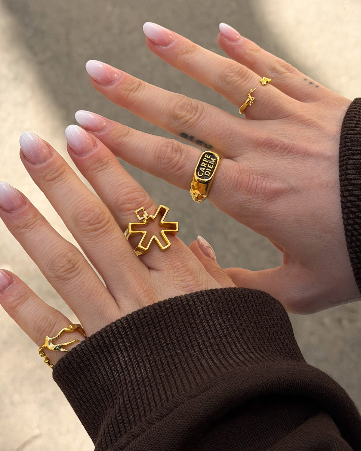 POV photo of hands wearing gold rings including the Self Portrait Ring