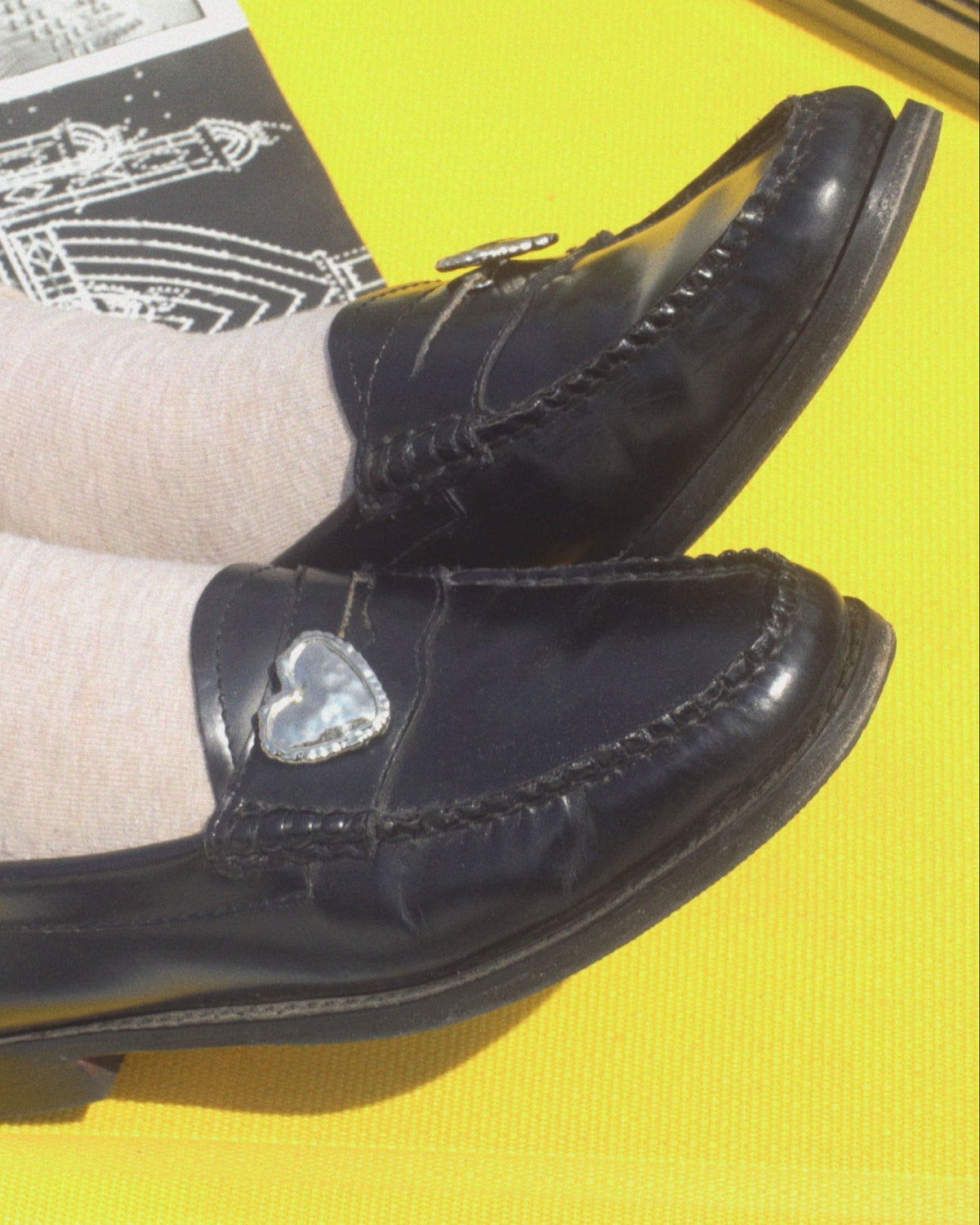 Heart Penny Pins worn on a yellow background