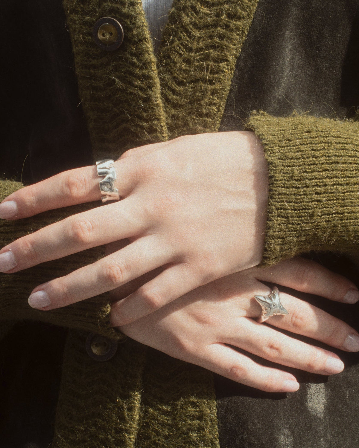 Human Ring in silver next to other silver rings worn