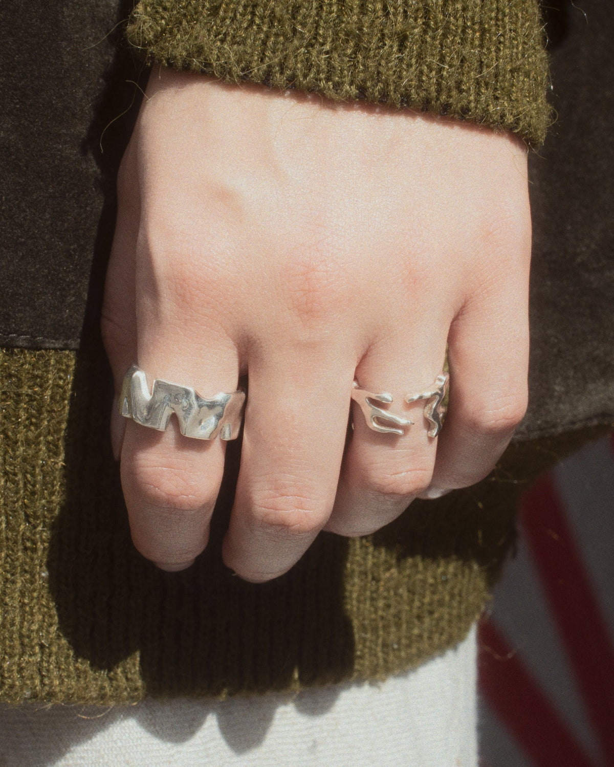 Human Ring in silver next to the Dance Ring worn