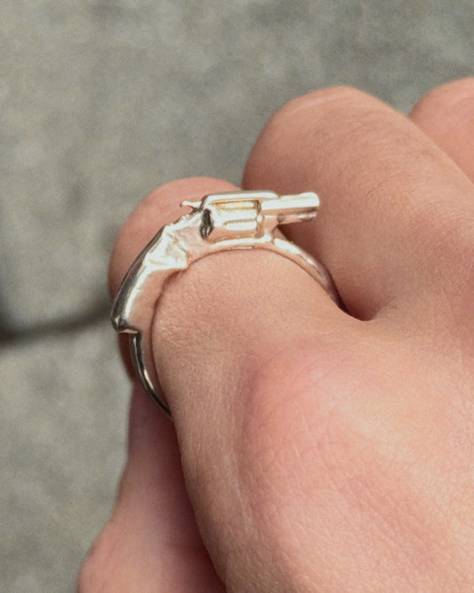 side view of the Revolver Ring in silver worn on index finger