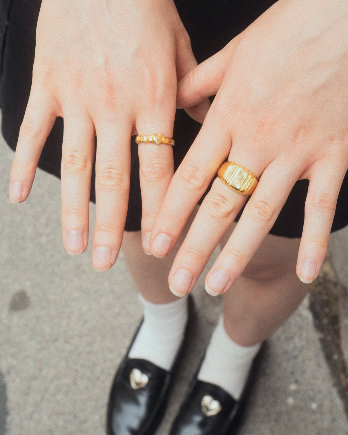 Daydream Ring in gold worn with other gold rings by female in skirt