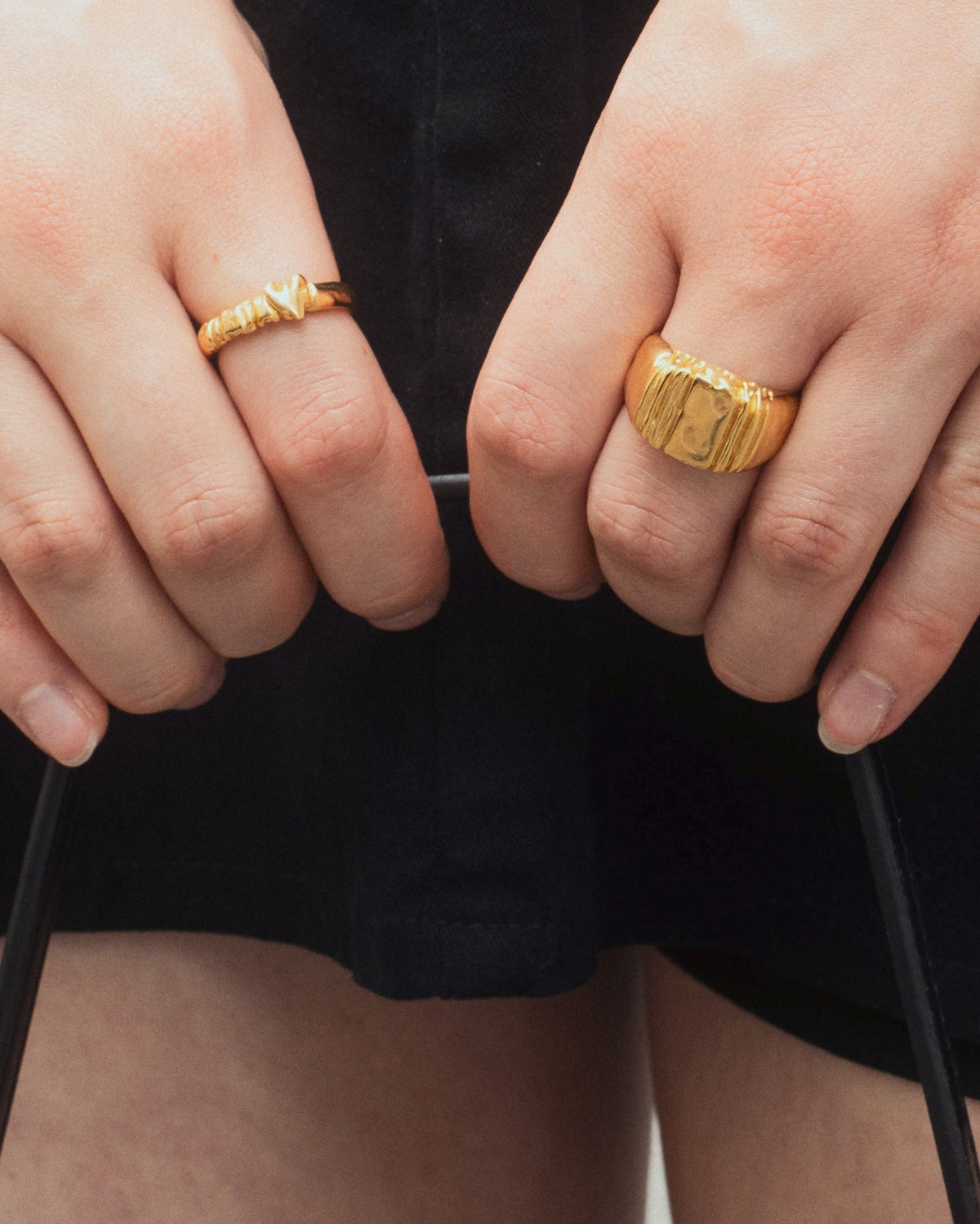 Daydream Ring in gold on hand holding a purse