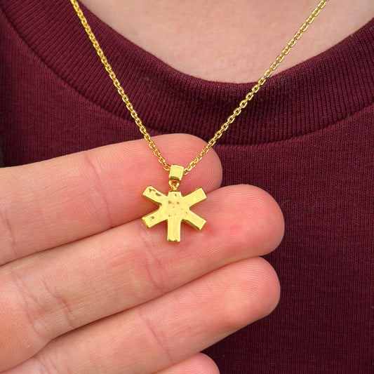 Self-Portrait Necklace holding pendant in hand while being worn in gold by female