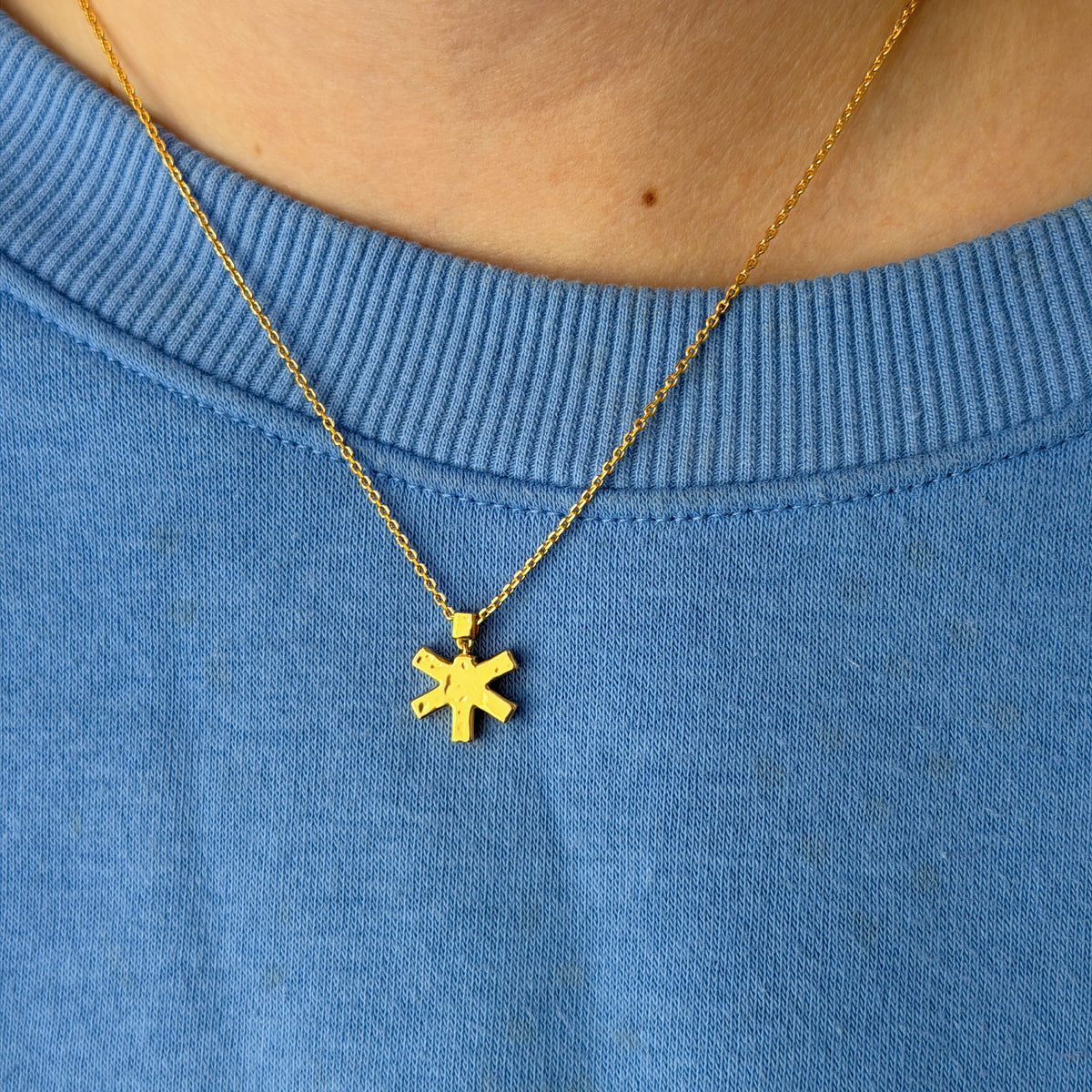 Self-Portrait Necklace in gold worn with a blue sweater