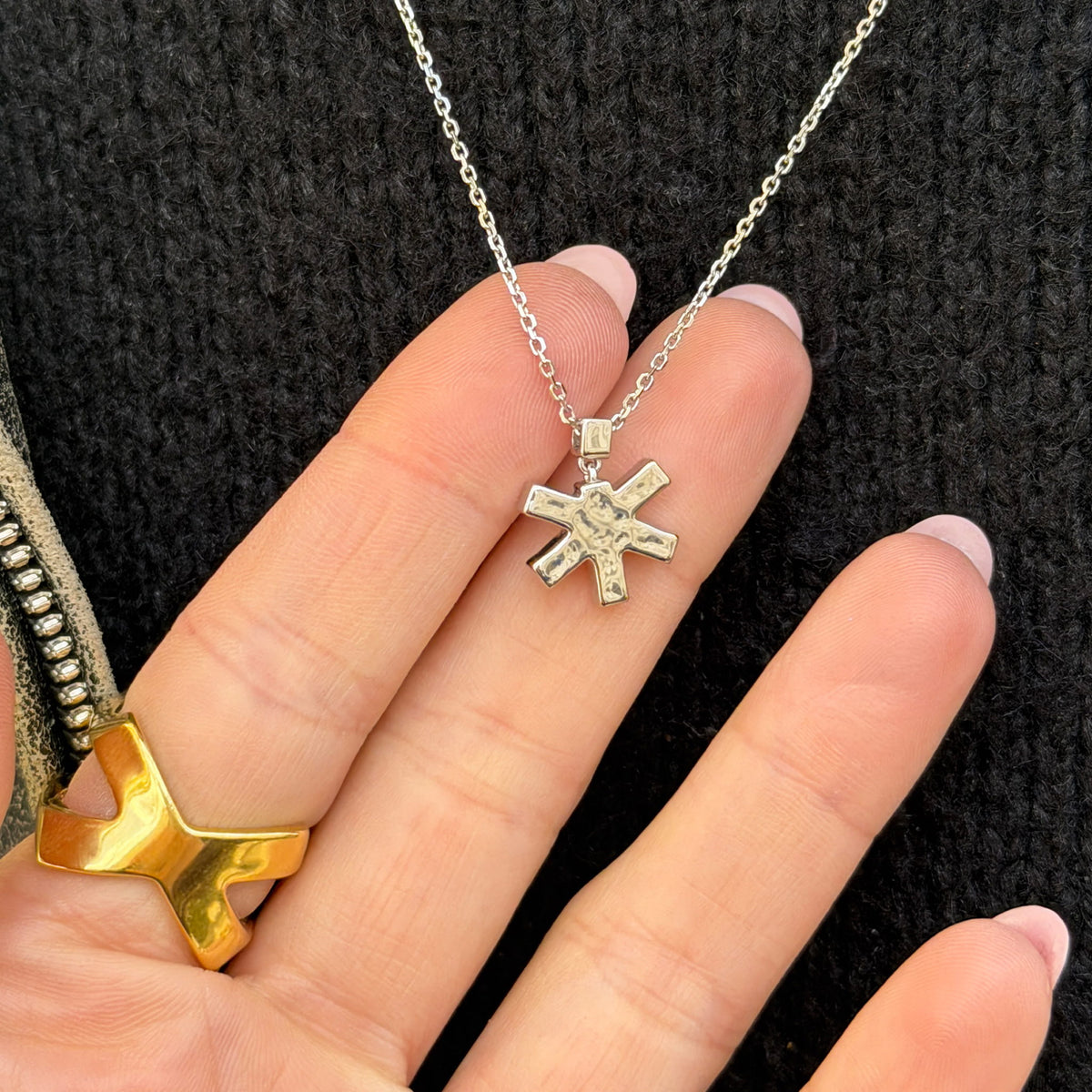Self-Portrait Necklace in silver with a hand holding the pendant