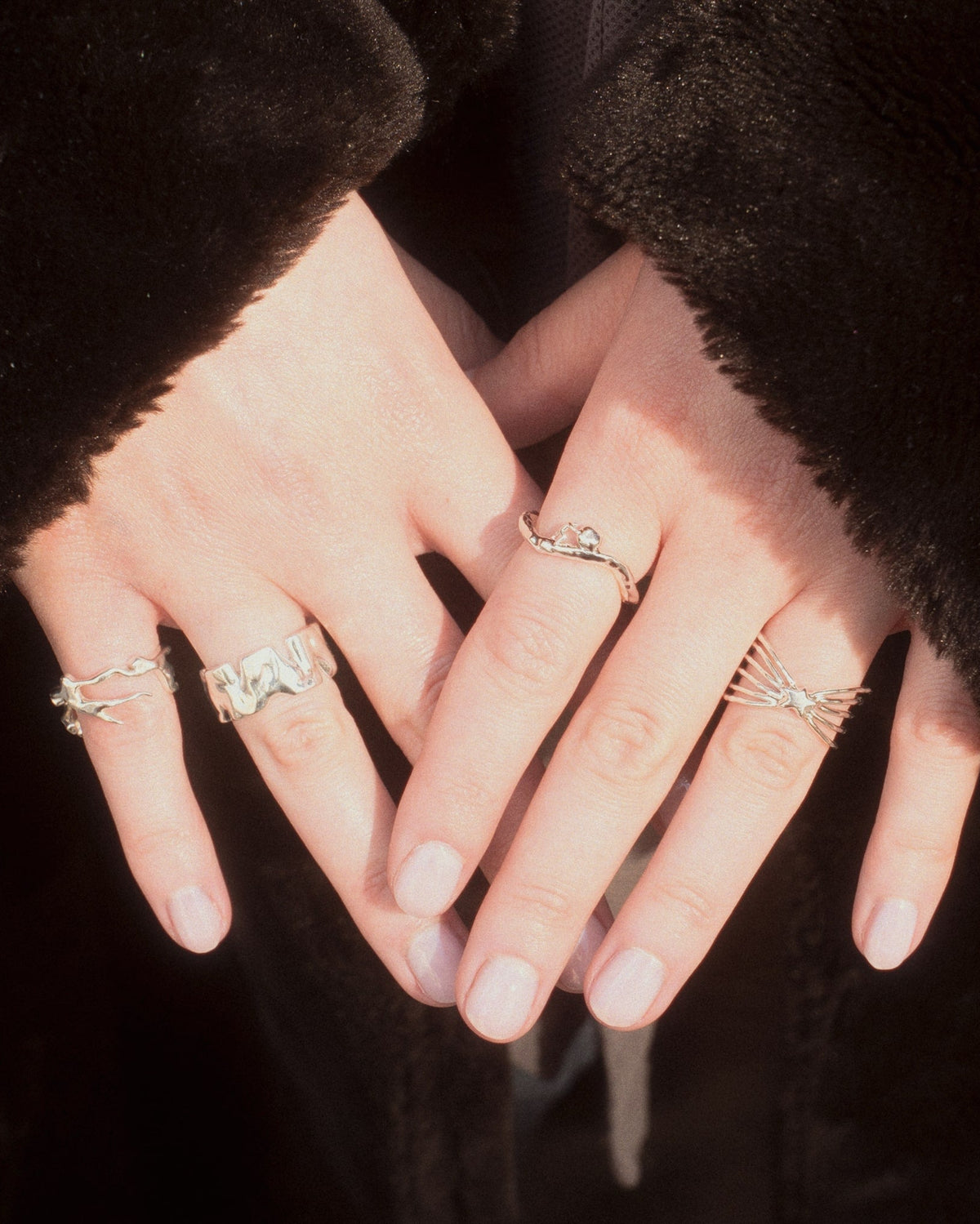 female in a coat showing her silver rings including the Shine Ring